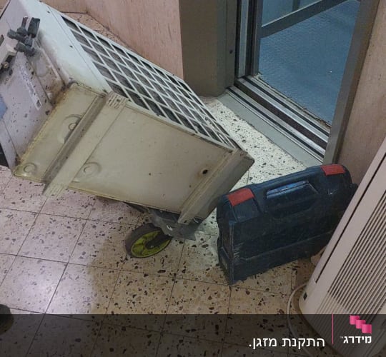 יחידת מזגן על גלגלים ליד מעלית